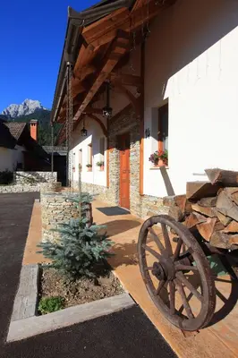 a stone building with a wheel in front of it at Pod Ponco Apartments in Kranjska Gora