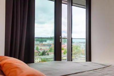 a bedroom with a bed and large glass windows at Slovenia Crib in Ljubljana