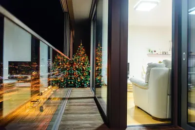 a christmas tree in a living room with a window at Slovenia Crib in Ljubljana