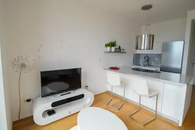 a living room with a counter with a tv and chairs at Slovenia Crib in Ljubljana