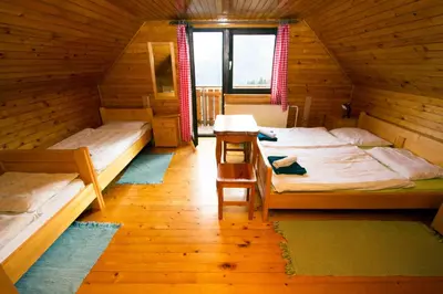a room with two beds in a wooden house at Turistična kmetija Perk in Solčava