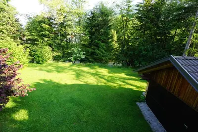 a yard with a green lawn with a shed at Apartma Židan in Kranjska Gora