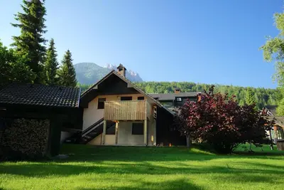 a house in a yard with a green lawn at Apartma Židan in Kranjska Gora