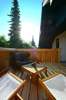a wooden deck with a table and a couch at Apartma Židan in Kranjska Gora
