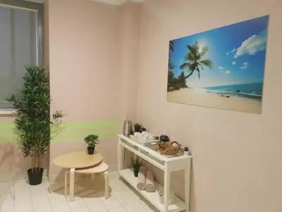 a white room with a table and a picture of a beach at Sport Hotel Ljubljana in Ljubljana