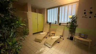 a waiting room with chairs and a table and a window at Sport Hotel Ljubljana in Ljubljana