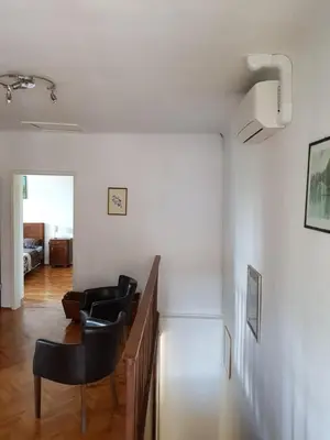 a living room with chairs and a table and white walls at Vila Dane in Sežana