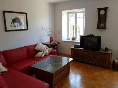 a living room with a red couch and a tv at Vila Dane in Sežana