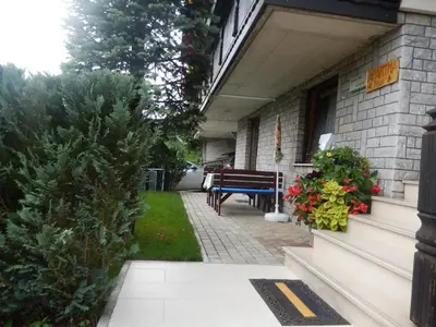a porch of a building with a bench and plants at Apartment Dijak in Bohinj