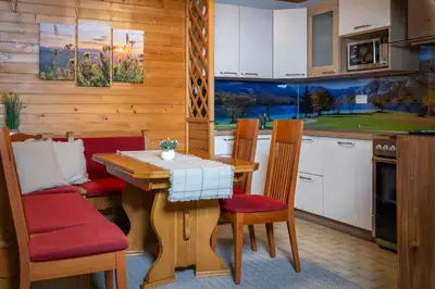 a kitchen with a wooden table and chairs and a kitchen with a counter at Apartment Dijak in Bohinj