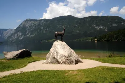 a statue of a horse on top of a rock in front of a lake at Apartment Dijak in Bohinj