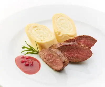a plate of meat and bread and a piece of cheese at Hotel Delalut in Ravne na Koroškem