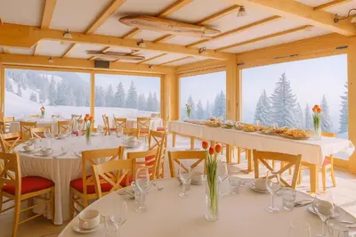 a dining room with tables and chairs with snow at Hotel Krvavec in Cerklje na Gorenjskem