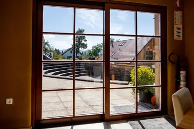 a large glass door with a view of a building at Youth Hostel Arsviva in Stari Trg pri Ložu