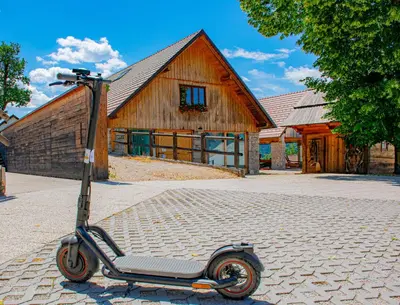 a scooter parked in front of a building at Youth Hostel Arsviva in Stari Trg pri Ložu