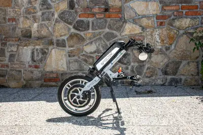 a motorcycle parked in front of a stone wall at Youth Hostel Arsviva in Stari Trg pri Ložu