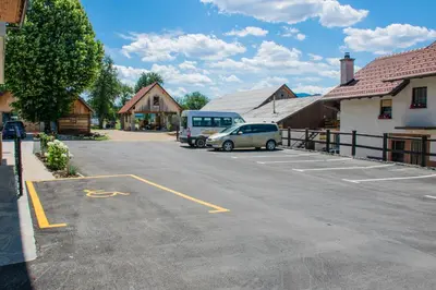 a parking lot with a van parked next to a building at Youth Hostel Arsviva in Stari Trg pri Ložu