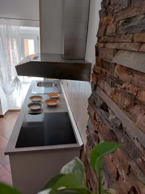 a kitchen with a stove and a brick wall at Soča House Tolmin in Tolmin