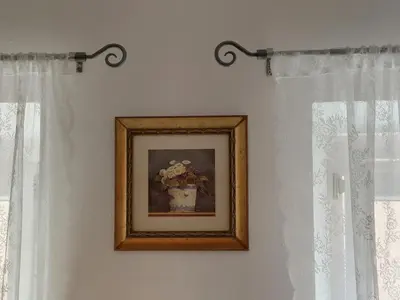 a picture of a vase of flowers on a wall at Soča House Tolmin in Tolmin