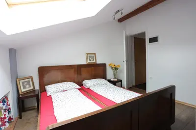 a bedroom with a large bed with a wooden headboard at Soča House Tolmin in Tolmin