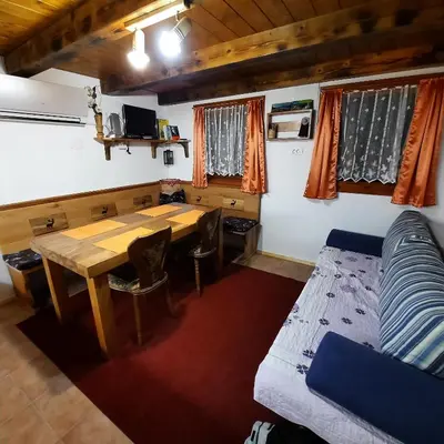 a room with a table and a couch and a bed at Jelenov breg pod Matajurem in Kobarid