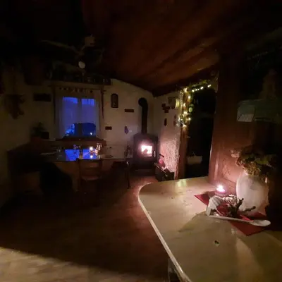 a dark living room with a table and a fireplace at Jelenov breg pod Matajurem in Kobarid
