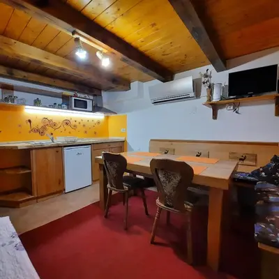 a kitchen with a wooden table and chairs at Jelenov breg pod Matajurem in Kobarid