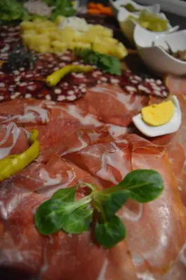 a close up of a pizza with meat and vegetables at Jelenov breg pod Matajurem in Kobarid