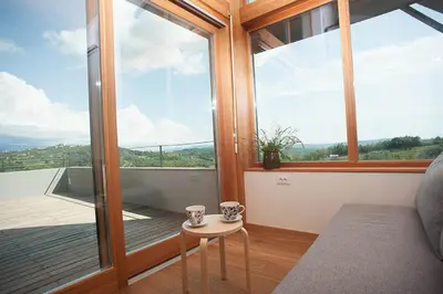 a room with a large window and a table with cups on it at Apartment Oton Reya in Dobrovo