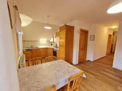 a kitchen with a table and a table and chairs at Apartments Karmen in Rateče