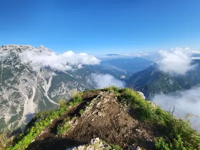a view from the top of a mountain with clouds at Apartments Karmen in Rateče
