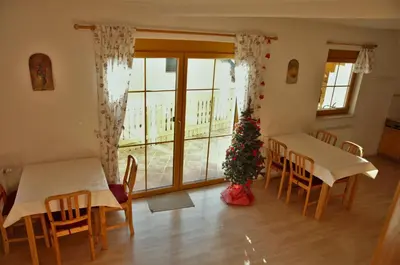 a room with two tables and a christmas tree at Apartments Karmen in Rateče