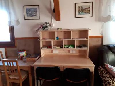 a room with a wooden table and chairs and a desk at Tourist Farm Znidarjevi in Kožljek