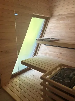 a sauna with a window in a wooden room at Apartments Beeland Skok in Mozirje