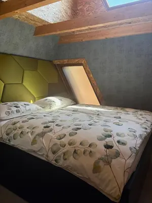 a bed with a comforter in a room at Apartments Beeland Skok in Mozirje