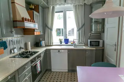 a kitchen with a stove top oven next to a window at Tomas's apartment in Ljubljana