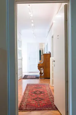 an open door to a hallway with a rug and a piano at Tomas's apartment in Ljubljana