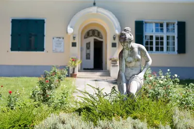a statue of a woman holding a fish in front of a building at Apartment Vila Golf in Rogaška Slatina