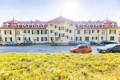 a large building with cars parked in a parking lot at Apartment Vila Golf in Rogaška Slatina