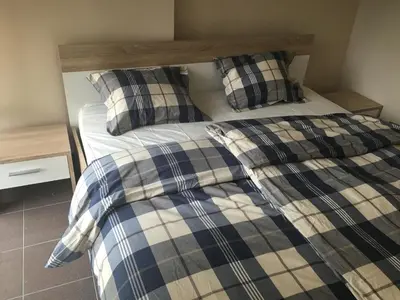 a bed with plaid sheets and pillows in a room at Old part Apartments Banjac in Maribor