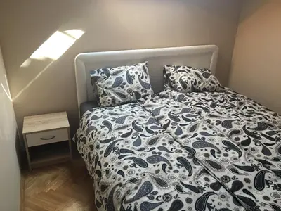 a bedroom with a bed with a blue and white comforter at Old part Apartments Banjac in Maribor