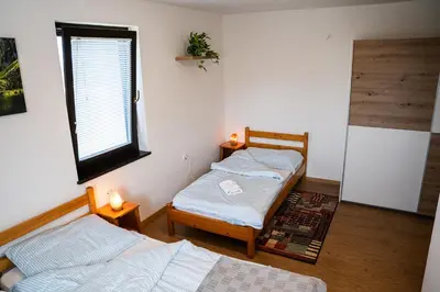 two twin beds in a room with a window at Adventure Farm in Štore