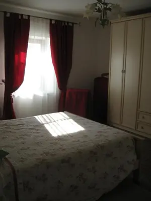 a bedroom with a bed and a window with red curtains at Country House Lokev in Lokev