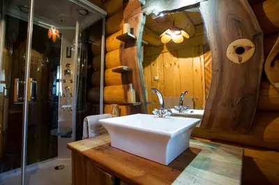 a bathroom with a sink in a wooden wall at Village Cottage - Koča na vasi in Nazarje