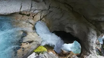 a view of a waterfall in a rock cave at Apartments Wallas in Bovec