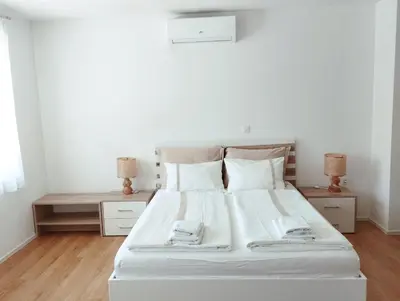 a white bed with white sheets and pillows in a bedroom at Apartments Wallas in Bovec