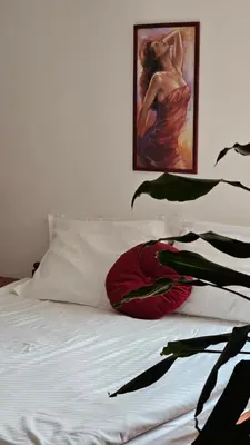 a bedroom with a bed with a painting on the wall at Guest House Pod Grebenom in Podčetrtek