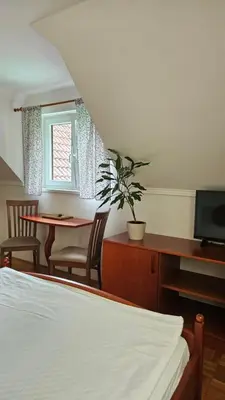 a bedroom with a bed and a desk and a table at Guest House Pod Grebenom in Podčetrtek