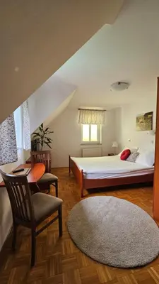 a bedroom with a bed and a chair and a desk at Guest House Pod Grebenom in Podčetrtek