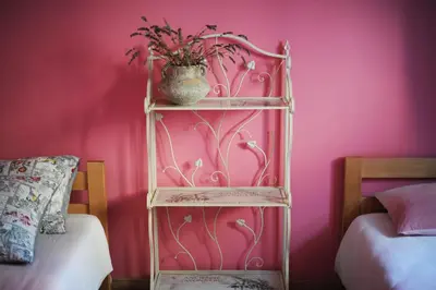 a pink room with a shelf with a vase of flowers at Apartments Life & Energy in Čatež ob Savi